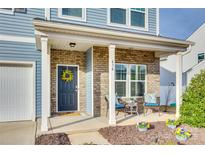 Inviting front porch with brick accents, seating, and blue door with floral wreath at 634 Gants Rd, York, SC 29745