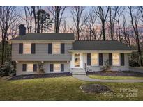 Charming two-story home with a blend of shingle and brick exterior, complemented by black shutters and a well-manicured front yard at 6736 Burlwood Rd, Charlotte, NC 28211