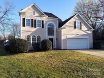 Charming two-story home with a well-manicured lawn and attached two-car garage on a sunny day at 9135 Stoney Corner Ln, Charlotte, NC 28210