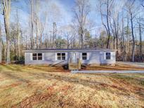 Charming single-story home with gray siding, white trim, and a newly built wooden porch and steps at 1085 Cedar Hill Dr, Rockwell, NC 28138