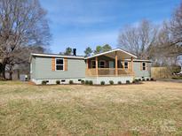 Charming home with a welcoming porch, neutral siding, and complemented by neat landscaping at 1324 Highland Bluff Ct, Lincolnton, NC 28092