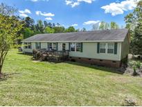 Charming single-story home featuring a spacious wooden deck, green shutters, and a well-maintained lawn at 1766 Duckwood Rd, Lancaster, SC 29720