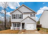 Charming two-story home with gray siding, a white picket fence on the front porch, and an attached one-car garage at 2808 Yurman Rd, Charlotte, NC 28214