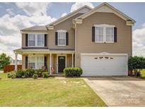Charming two-story home boasts a well-manicured lawn, covered porch, and attached two-car garage at 3841 Shasta Cir, Clover, SC 29710