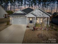 Charming single-Gathering home featuring stone accents, a two-car garage, and a welcoming front porch at 4321 Duplin Dr, Charlotte, NC 28214