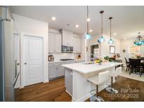 Modern kitchen featuring gray cabinets, stainless steel appliances, and a stylish island with seating at 4321 Duplin Dr, Charlotte, NC 28214