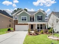 Charming two-story home with manicured lawn, stone accents, and attached two car garage at 4329 Hunton Dale Nw Rd, Concord, NC 28027