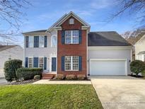 Charming two-story home with a brick facade, blue shutters, attached two-car garage, and a well-maintained lawn at 4910 Summerside Dr, Clover, SC 29710
