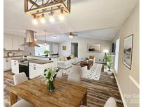 Bright, open-concept living room with modern furniture, stylish rug, and adjacent kitchen, perfect for entertaining at 7154 Woodcock Trl, Stanley, NC 28164