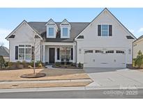 Charming white home features a manicured lawn, a two car garage and classic black window shutters at 82116 Standing Oak Dr, Charlotte, NC 28278