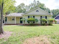 Charming home with a covered porch and well-maintained front yard landscaping at 9117 Landsburg Ln, Charlotte, NC 28210