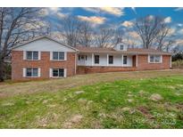 Charming brick home featuring classic white shutters and a welcoming front porch at 107 S Myrtle Ave, China Grove, NC 28023