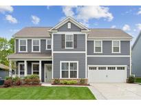 Charming two-story home with gray siding, white trim, and a well-manicured lawn on a sunny day at 1082 Dorsey Dr, Fort Mill, SC 29715