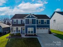 Charming two-story home featuring a well-manicured lawn and attached two car garage, offering comfort and curb appeal at 1082 Dorsey Dr, Fort Mill, SC 29715