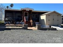 Charming home featuring a screened in porch, a brick pathway and a storage shed at 114 Dove Ln, New London, NC 28127