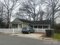 Charming single-story home with a white picket fence, inviting curb appeal and parking area at 1301 N Mcdowell St, Charlotte, NC 28205