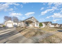 Charming single-story home featuring a covered front porch with stone accents and a well-maintained front yard at 1720 Dewberry Pl, Salisbury, NC 28146