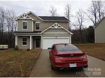 Charming two-story home features a red car parked on the driveway at 232 Sugar Hill Rd, Troutman, NC 28166