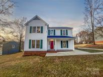 Charming two-story home with white siding, green shutters and a vibrant red front door at 316 Epperstone Ln, Matthews, NC 28105