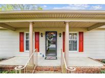 Charming home entrance featuring a covered porch with red shutters and decorative wreath on the front door at 1007 Wentworth Dr, Kannapolis, NC 28081