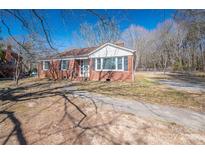Charming brick home with a well-maintained front yard, a paved walkway, and mature trees at 1547 Kings Rd, Shelby, NC 28150