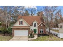 Charming two-story home with a well-manicured lawn and brick accents creating curb appeal at 207 Pebble Creek Xing, Fort Mill, SC 29715