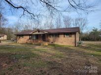 Brick single-story home featuring a covered porch and a well-maintained lawn at 222 Weldon Cir, Mount Holly, NC 28120