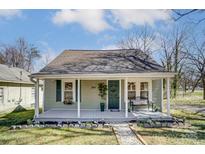 Charming home with a covered front porch, garden, and a welcoming stone walkway, offers beautiful curb appeal at 240 N Lackey St, Statesville, NC 28677