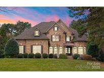 Beautiful brick home features mature landscaping, a multi-gabled roof, and decorative shutters for enhanced curb appeal at 308 Covington Xing, Weddington, NC 28104