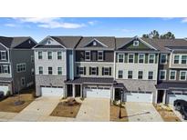 An aerial view of newly constructed townhomes, each with a one-car garage and individual architectural design at 419 Burr St, Indian Trail, NC 28079