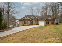 Charming brick home with attached garage and well-manicured front yard on a sunny day at 4543 Stonesthrow Dr, Denver, NC 28037