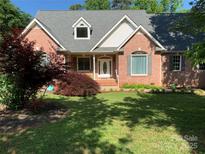 Charming brick home featuring a well-manicured lawn, mature landscaping, and a welcoming front entrance at 912 Silver Charm Ln, York, SC 29745