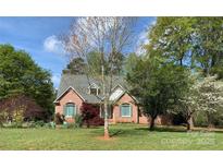 Charming red brick home with a well-manicured lawn and mature trees in a peaceful setting at 912 Silver Charm Ln, York, SC 29745