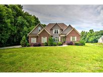 Charming brick home with well-manicured lawn and lush landscaping at 1011 Duntov Dr, Monroe, NC 28110