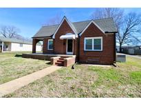 Charming brick home with a covered front porch and well-maintained lawn under a clear, blue sky at 104 N 9Th St, Bessemer City, NC 28016
