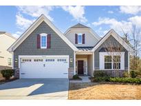Charming two-story home showcasing a well-maintained lawn, a two-car garage, and decorative shutters at 12655 Belmont Mansion Dr, Charlotte, NC 28273