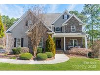 Charming two-story home with stone accents, well-manicured landscaping, and inviting walkway at 165 Blue Ridge Trl, Mooresville, NC 28117