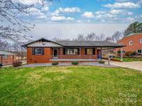 Charming brick home features a well-manicured lawn and a covered carport at 337 Glenwood Dr, Mooresville, NC 28115