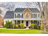 Charming two-story home with stone accents, black shutters, and lush landscaping at 341 Fischer Rd, Fort Mill, SC 29715