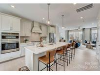Modern kitchen features a large island with seating, stainless steel appliances, and stylish pendant lighting at 348 Catawba Ave, Davidson, NC 28036