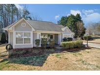 Charming single-story home featuring a well-manicured front yard with mature landscaping and a welcoming front porch at 7200 Morning Dew Ct, Denver, NC 28037