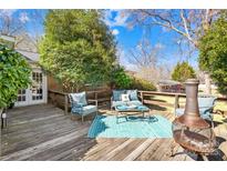 Inviting back deck with outdoor seating, fire pit, and lush greenery perfect for relaxation at 827 Lakeside Cir, Lancaster, SC 29720