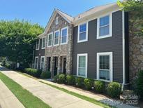 Beautiful home with stone accents, horizontal siding, large windows, and manicured landscaping along the sidewalk at 1019 Archibald Ave, Fort Mill, SC 29708