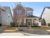 Charming two-story home with a stone facade and inviting front porch at 13332 Caite Ridge Rd, Davidson, NC 28036