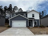 Two-story home showcasing a two-car garage and a combination of white and gray siding at 1413 Windy Park Dr, Stanley, NC 28164