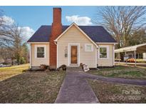 Charming cottage-style home with a brick chimney, quaint front yard, and inviting walkway at 148 Linwood Dr, Albemarle, NC 28001