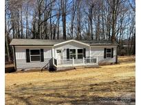 Charming single-story home features gray siding, black shutters, and a welcoming front porch with black metal railings at 3094 Hollywood Dr, Gastonia, NC 28052