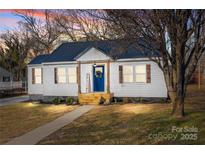 Charming home featuring a blue metal roof, wood accents, and a welcoming blue front door at 312 Motz Ave, Lincolnton, NC 28092