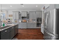 Well-designed kitchen with gray cabinets, stainless steel appliances and a decorative tile backsplash at 3608 Mcpherson St, Waxhaw, NC 28173