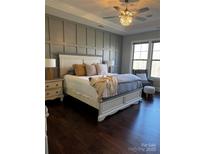 Comfortable main bedroom features paneling and a stylish ceiling fan with gleaming hardwood floors at 3608 Mcpherson St, Waxhaw, NC 28173